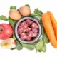 Ingredients of barf raw food recipe for dogs consisting meat, eggs and vegetable
